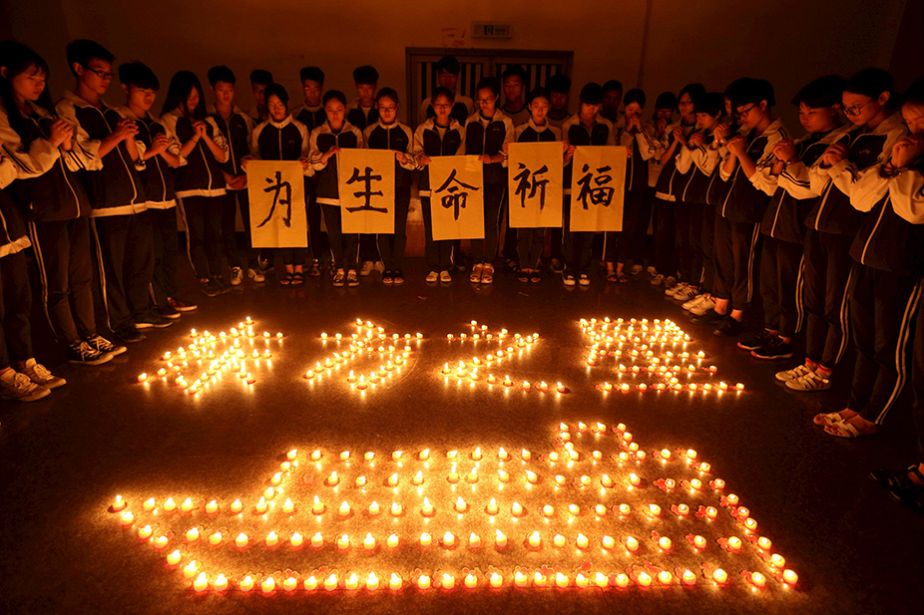 Des étudiants chinois prient pour les victimes de la catastrophe du ferry