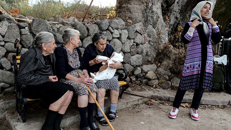 Trois vieilles femmes grecques prennent soin d'un bébé migrant à Lesbos