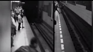 A woman 'walks off' after falling under train - Video