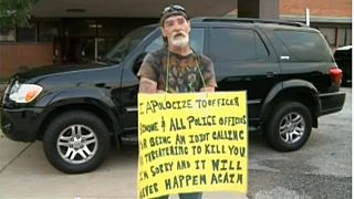 Man who threatened police made to stand with sign calling himself an idiot