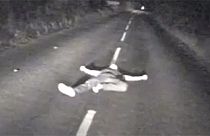 Watch: Drunk man seconds from death after lying down in middle of British road