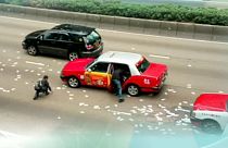Rush for money after security van spills banknotes on Hong Kong road