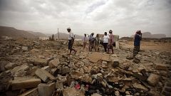 Image: Tribesmen stand on the rubble of a building destroyed by a U.S. dron