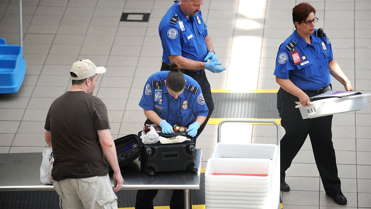 Image: A Transportation Security Administration (TSA) agent checks the lugg