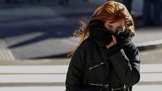Image: A Woman Bundles Up Against the Cold Temperature
