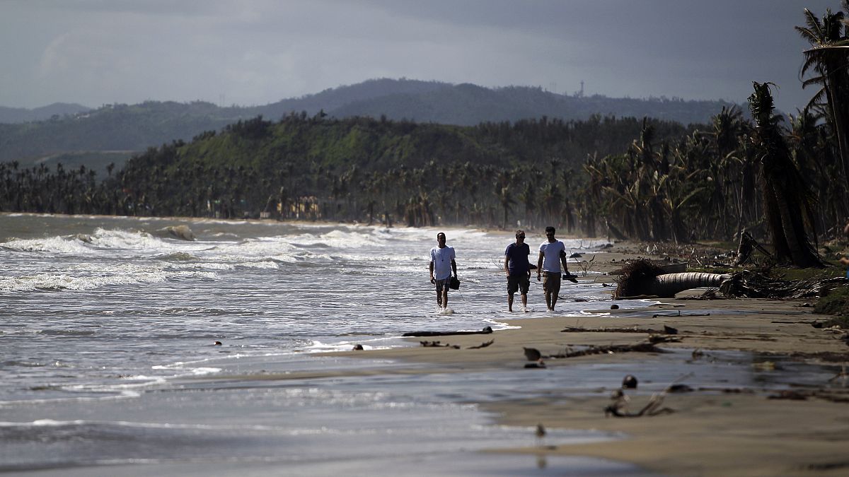 Image: Tourists wade in the water along the beach in the Punta Santiago bea