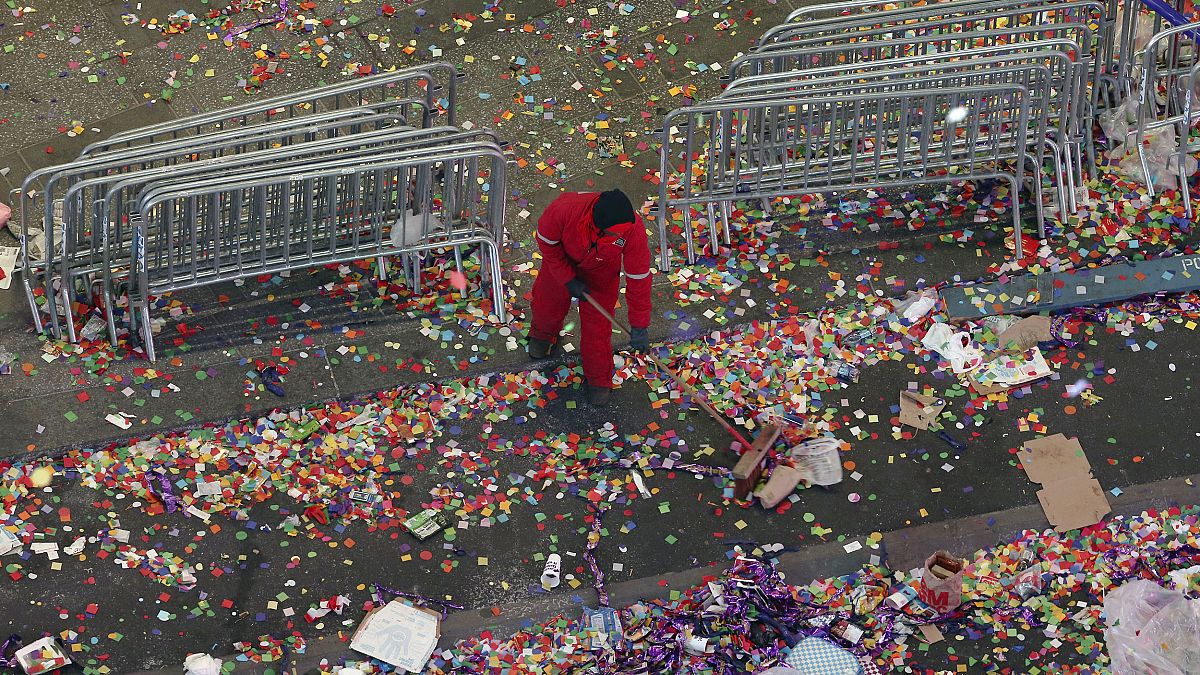 Image: A member of the cleanup crew sweeps confetti in New York's Times Squ