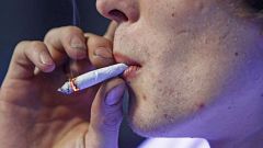 Image: Russell Diercks smokes a half marijuana and tobacco joint inside of 