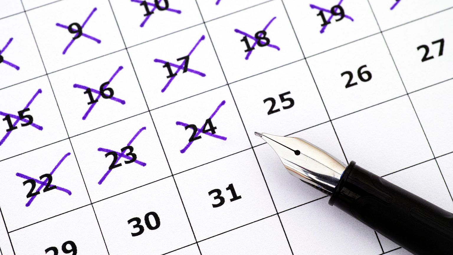 Image: Fountain pen lying on calendar with marking days