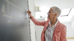 Businesswoman Drawing Chart On Blackboard In Her Office.