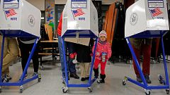 Image: Myla Gibson, 3, waits as her father Ken Gibson fills out a ballot fo