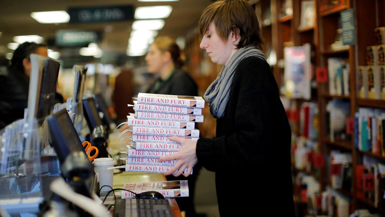 Image: An employee holds copies of the book "Fire and Fury: Inside the Trum