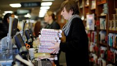 Image: An employee holds copies of the book "Fire and Fury: Inside the Trum