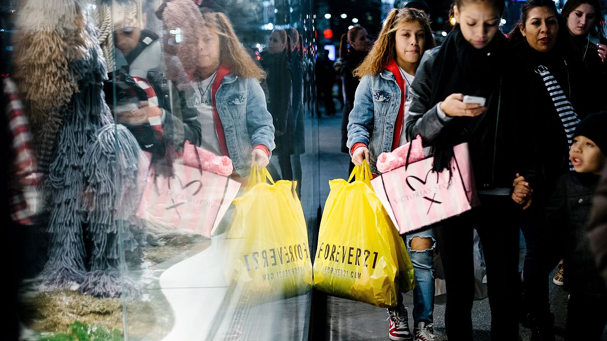 Image: People carry shopping bags outside a shopping mall