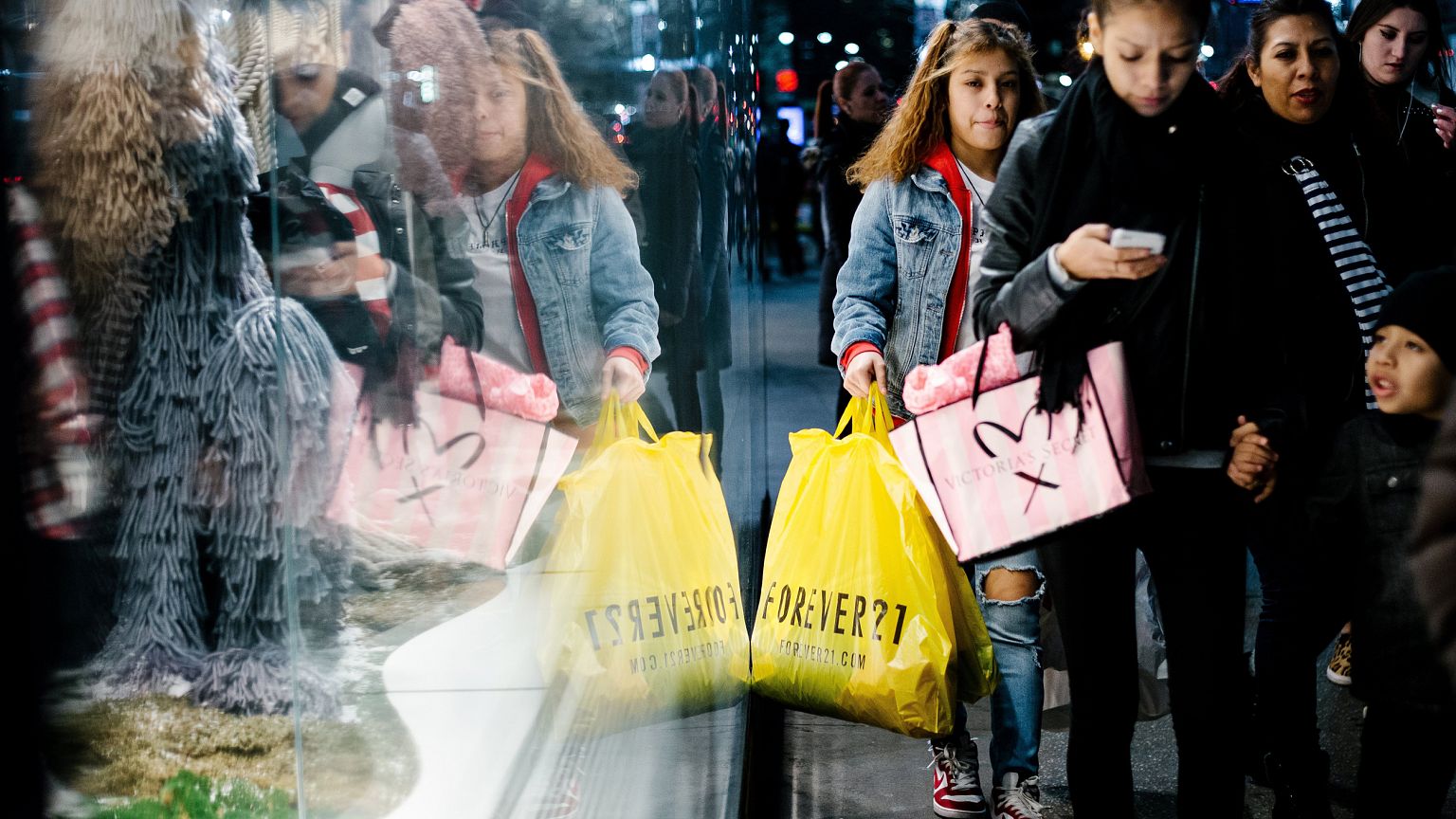 Image: People carry shopping bags outside a shopping mall