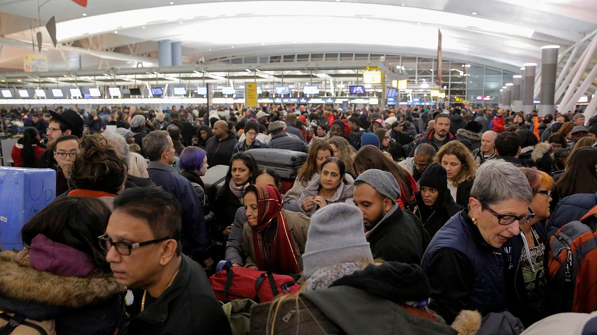 Image: Large crowds try to make their way through the departures area of Te