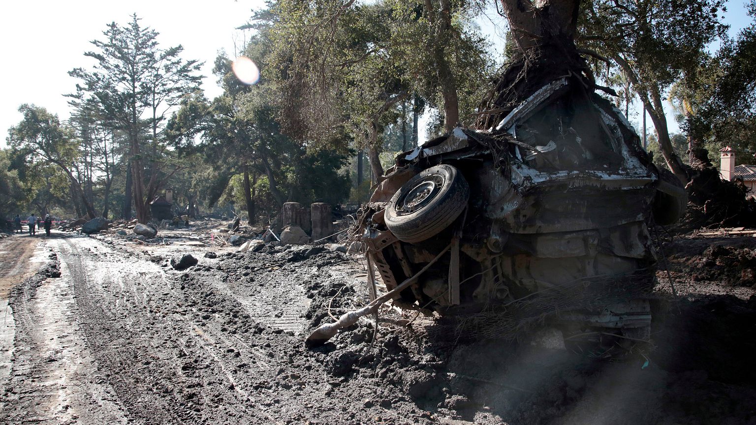 Image: Rescue workers search through properties after a mudslide in Monteci
