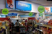 Image:  A customer waits at the counter of a CVS Pharmacy store in Pasadena