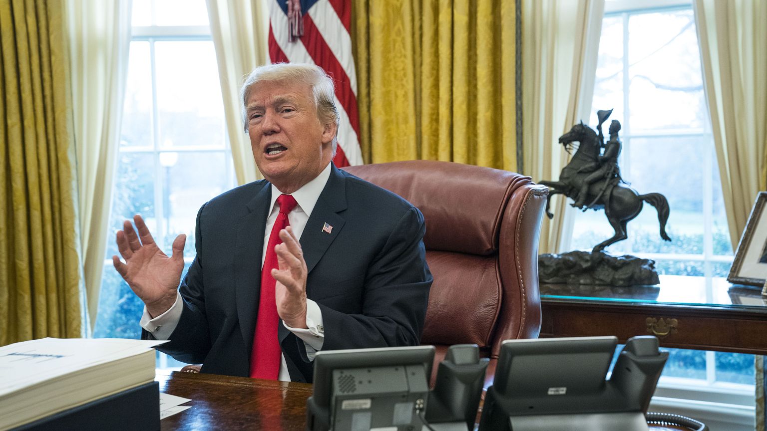 Image: President Donald Trump speaks to reporters after signing a sweeping 