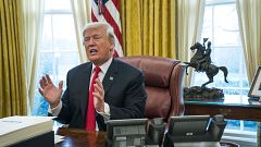 Image: President Donald Trump speaks to reporters after signing a sweeping 