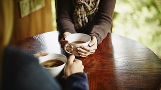 Image: Two women having tea at table in cabin