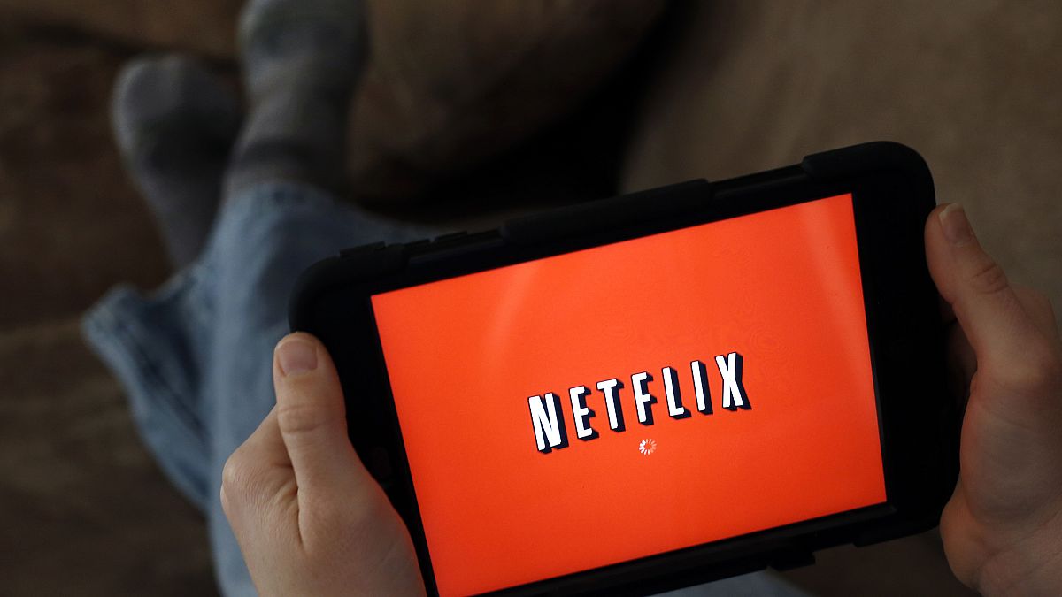 Image: A person displays Netflix on a tablet