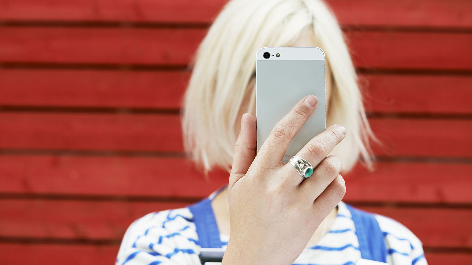 Image: woman holding up mobile for selfie