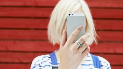 Image: woman holding up mobile for selfie