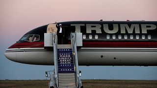 Image: Trump waves as he walks off his plane at a campaign rally in Colorad