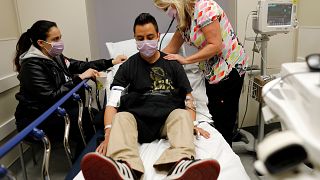 Image: Emergency room nurse Christine Bauer treats Joshua Lagade of Vista,