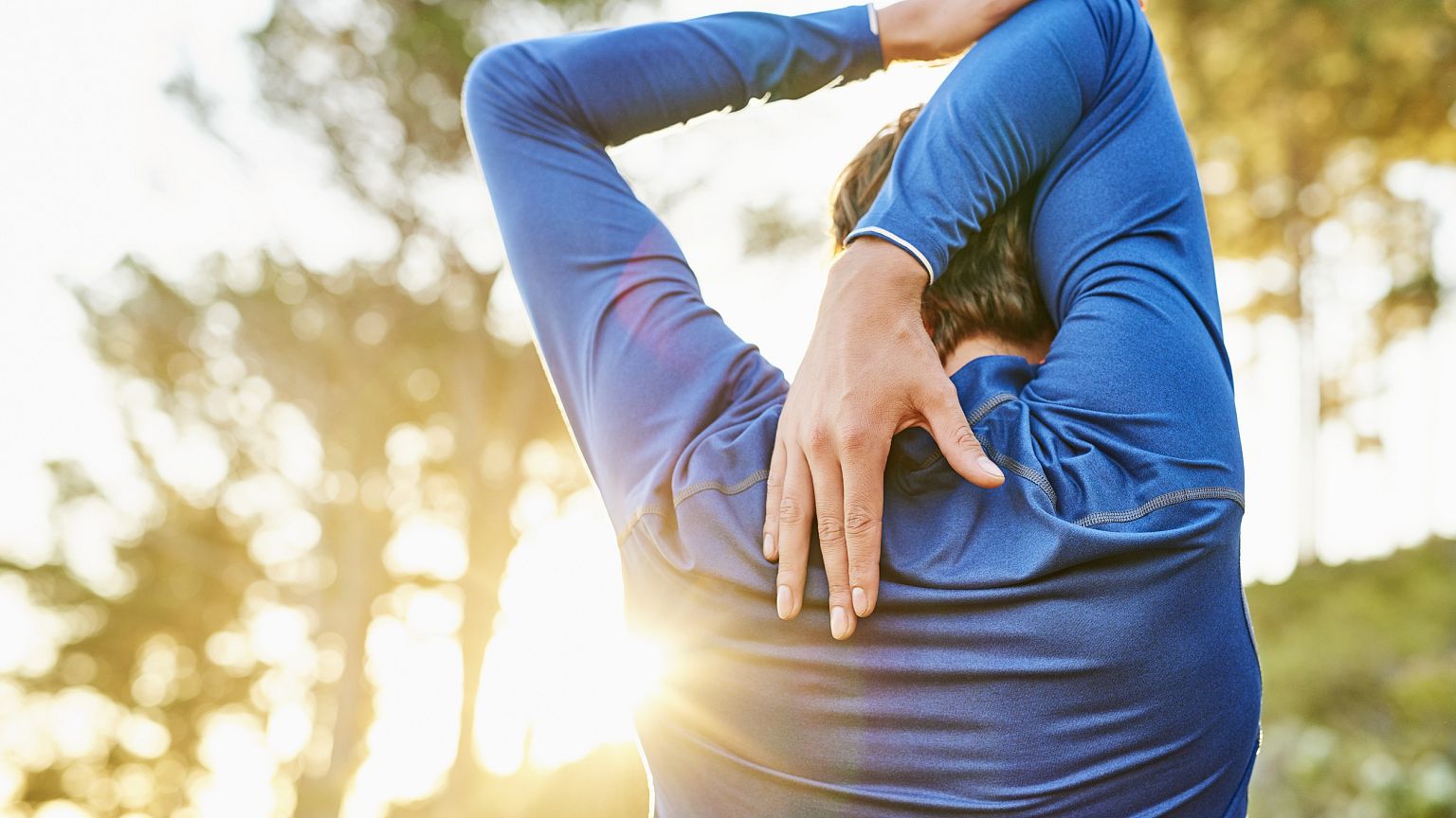 Young man stretching arm and shoulder outdoors