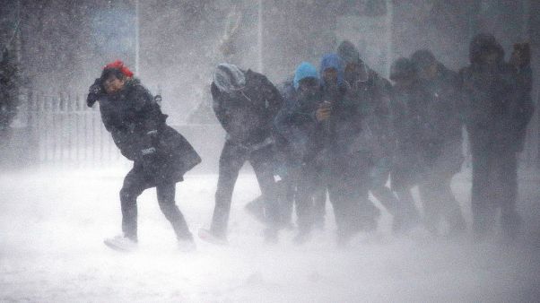 Image: People struggle to walk in the blowing snow during a winter storm Image: People struggle to walk in the blowing snow during a winter storm