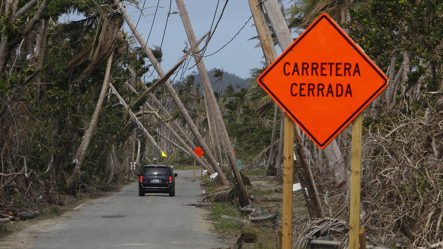 Image: A car drives under downed power lines in the aftermath of Hurricane 