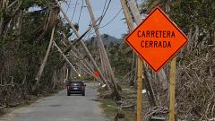 Image: A car drives under downed power lines in the aftermath of Hurricane 
