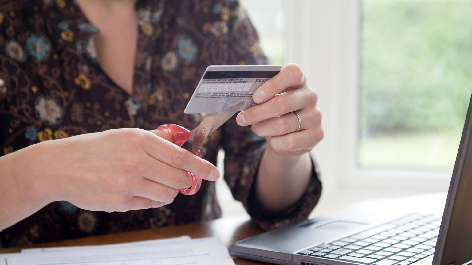 Image: Woman Cutting Credit Card with Scissors