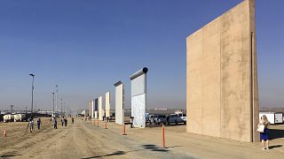 Image: People look at prototypes of a border wall