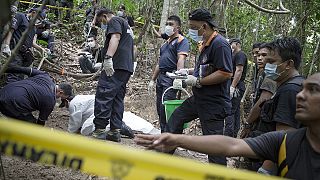 Forensic police in Malaysia exhume migrant corpses buried along the Thai border