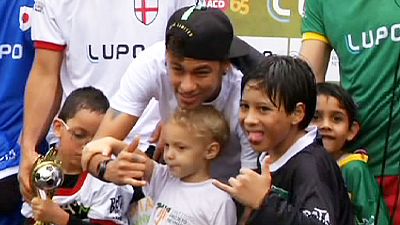 Neymar, a estrela brasileira, ajuda crianças deficientes a jogarem futebol.