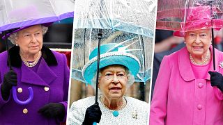 Queen Elizabeth II with umbrellas