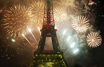 Eiffel Tower lit up by fireworks for Bastille Day