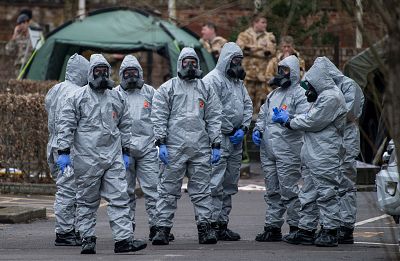 Military personnel wearing protective suits remove a police car and other vehicles from a public car park as they continue investigations into the poisoning of Sergei Skripal on March 11, 2018 in Salisbury.