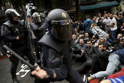 Police try to remove pro-referendum supporters sitting down on a street in Barcelona.