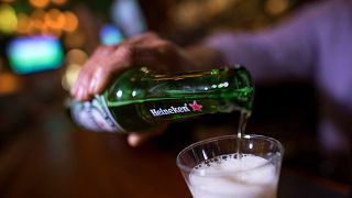 Image: A man pours Heineken beer in a glass