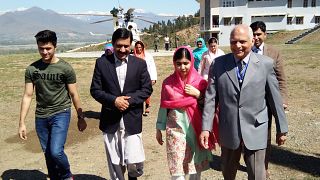 Image: Malala Yousafzai walks with her father, Ziauddin (2L), brother Atal