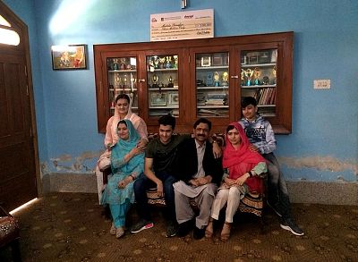 Malala Yousafzai, second right, poses in her old home with family and Pakistan Information Minister Marriyum Aurangzeb, left.