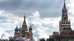 Image: People walk in front of St. Basil's Cathedral and the Kremlin on Red