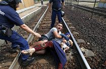 Migrants pulled from train tracks by Hungarian police