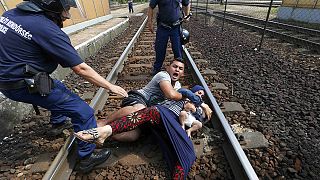 Migrants pulled from train tracks by Hungarian police