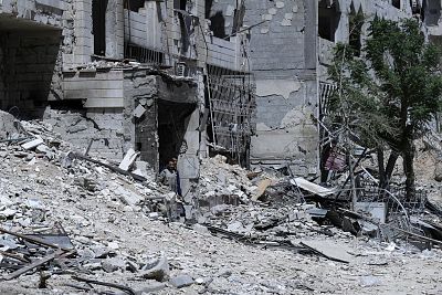 Syrians walk through destruction in the town of Douma, the site of a suspected chemical weapons attack, near Damascus, Syria on April 16, 2018. 