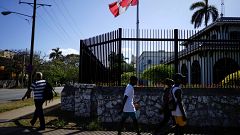 Image: People pass by the Canada's Embassy in Havana
